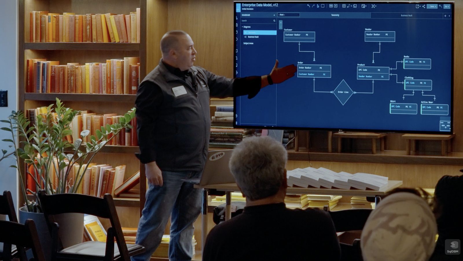 A SqlDBM trainer presenting an enterprise data model on screen to a seated group at a partner enablement session